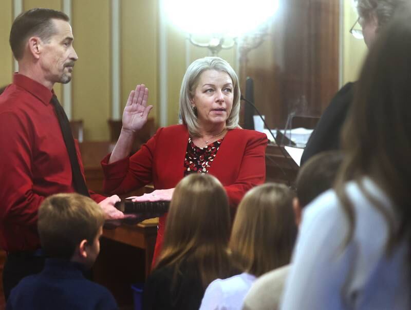 New DeKalb County Coroner Linda Besler, accompanied by her family, is sworn into office by Chief Judge Bradley Waller Monday, Dec. 2, 2024, during a ceremony at the DeKalb County Courthouse in Sycamore.