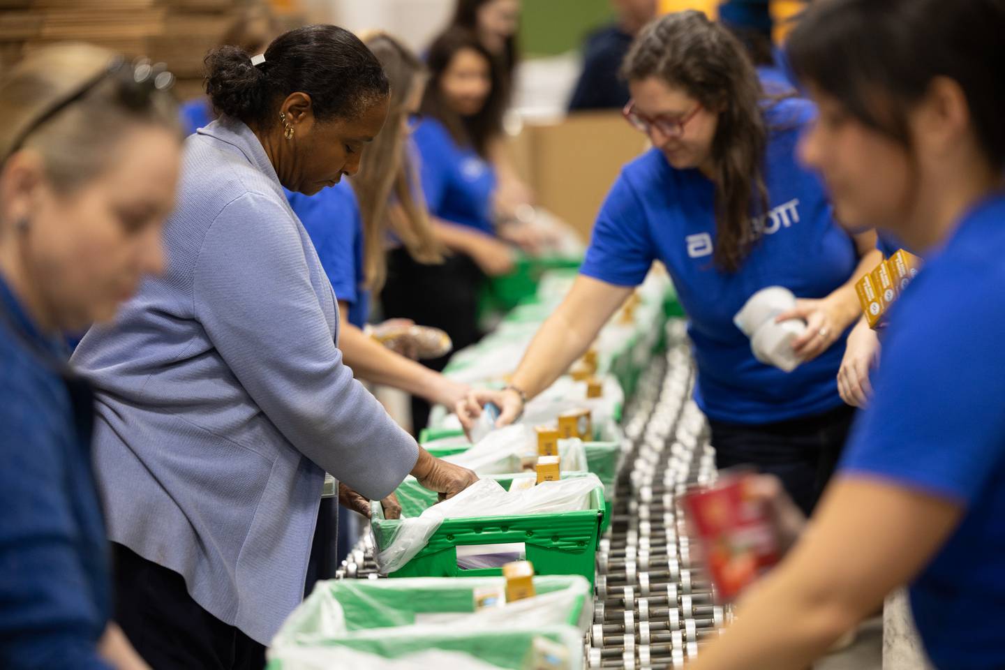 Abbott employees Wendy Willis (left) and Jessica Zar are among a group of the company's volunteers stocking food supplies for the Northern Illinois Food Bank BackPack Program. Abbott Fund donated $250,000 to the BackPack Program, which provides weekend meals to children and families in need.