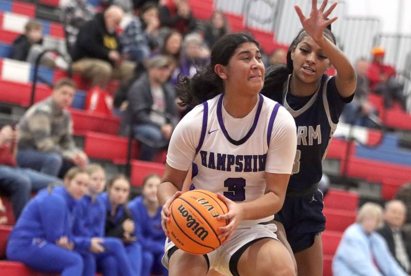 Hampshire’s Jiselle Lopez, front, gets past South Elgin’s Taleah Banner in varsity girls basketball Komaromy Classic tournament  action on Monday, Dec. 29, 2025, at Dundee-Crown High School in Carpentersville.