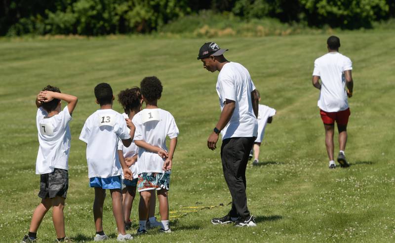 NIU football players pass along their skills and knowledge to kids attending the inaugural Legends of the 60115 Football Camp in DeKalb on Sunday, June 26, 2022.