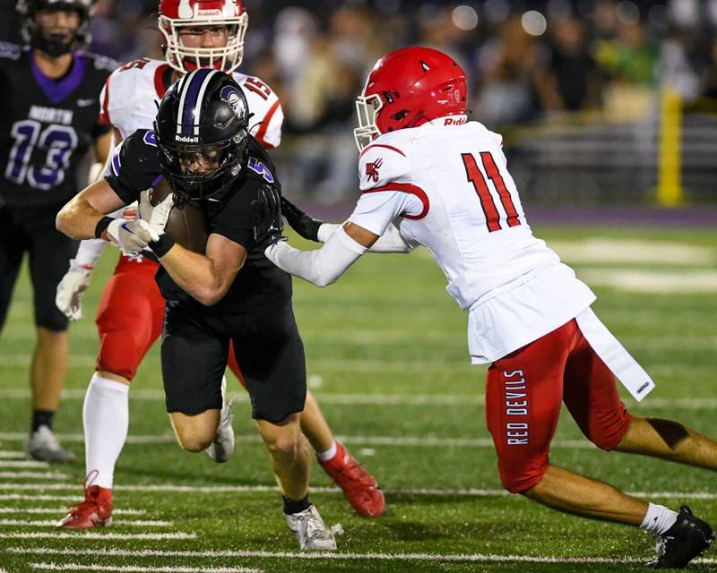 Downers Grove North's ball carrier Max Troha (5) gets pushed out of bounds by Hinsdale Central's defender Benjamin Munoz (11) during the game on Friday Sept. 12, 2025, held at Downers Grove North High School.