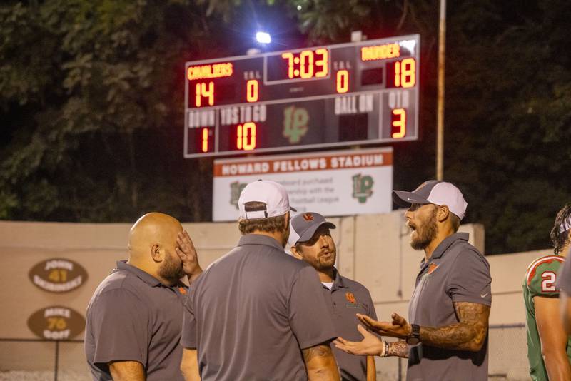 LaSalle-Peru football coaches discuss details of the close scoring game against Woodstock North during halftime on Sept. 8, 2023.