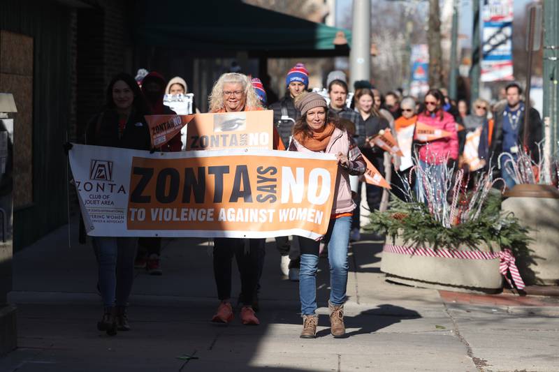 Supporters march along Chicago Street during a rally for ZONTA Says No To Violence Against Women on Tuesday in Joliet.