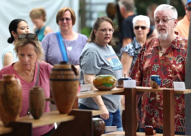 Visitors check out some of the work Saturday, July 26, 2025, at the Geneva Arts Fair in downtown Geneva.