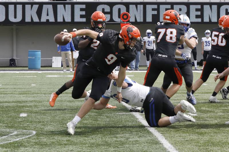 Wheaton Warrenville South quarterback Parker Brown scrambles with the ball Saturday, April 24, 2021 during their conference game at NIU against St. Charles North.