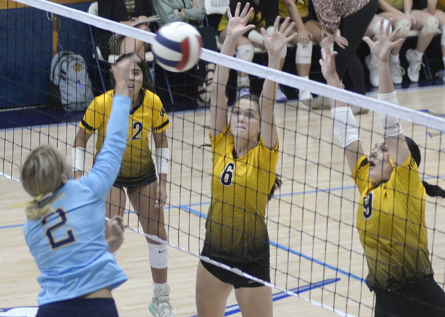 Marquette’s Anna Hjerpe works to get a shot past the blocking attempts of Reed-Custer’s Kaylee Tribble and Mackenzie Keller during the first set Monday at Marquette High School.