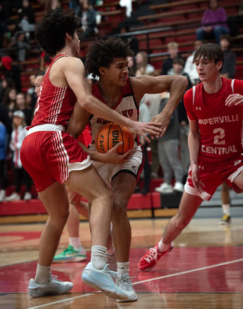 Bradley-Bourbonnais's DaJaun Brown, center, is tightly guarded by Naperville Central's Casey Cooperkawa, left, and Nathan Abrahamson, right, in a game on Monday, December 15, 2025.