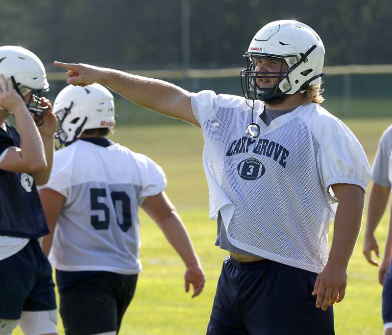 Cary-Grove's Jack Hissong explains blocking schemes to a teammate during Cary-Grove’s first football practice of the upcoming season on Monday, August 11, 2025, at Cary-Grove High School.