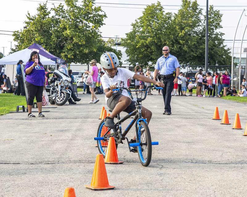 Colby Love tries out the bicycle obstacle course at the Joliet Police Department's National Night Out event Tuesday, Aug 5, 2025  in Joliet.