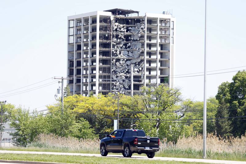 A vehicle heads east along Route 64 as demolition work started on the northwest corner of the tower building Friday, May 17, 2024 to bring down the last of the remaining structures at the shuttered Pheasant Run Resort in St. Charles. Since its closure, the resort property has attracted urban explorers and vandals.