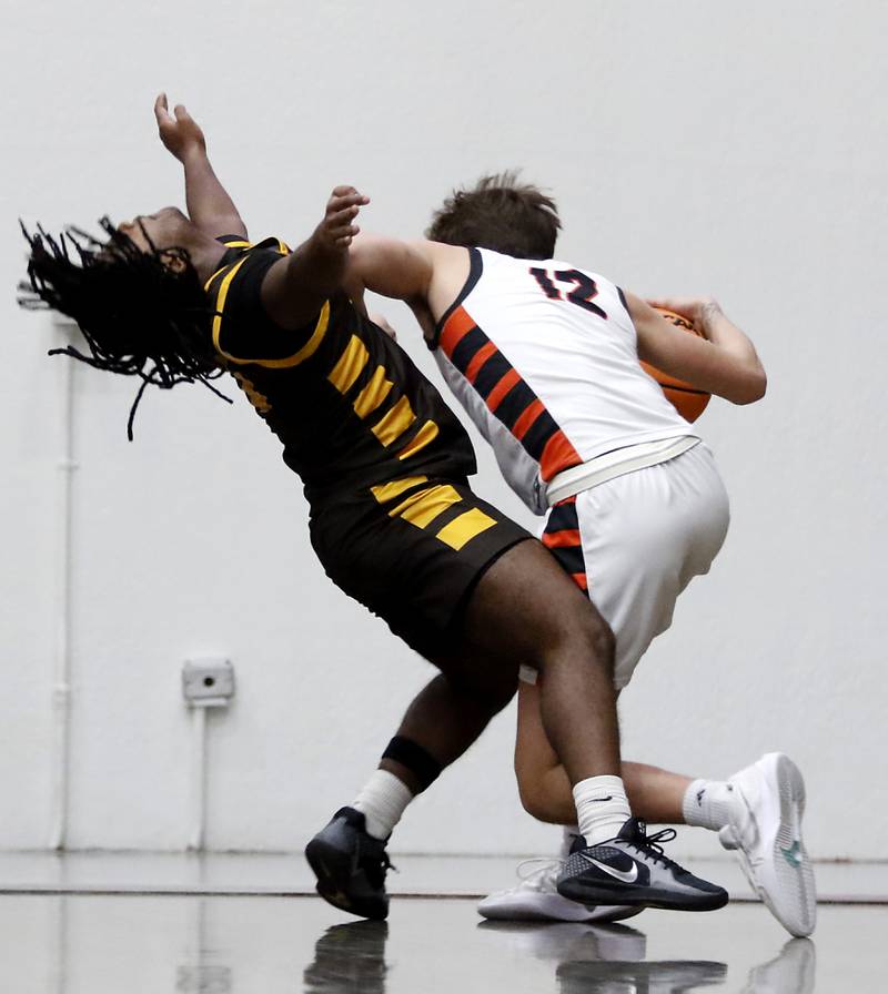 Jacobs' Emaan Thomas is fouled bt McHenry's Caleb Jett during an IHSA Class 4A McHenry Regional basketball game on Wednesday, Feb. 26, 2025, at McHenry High School.