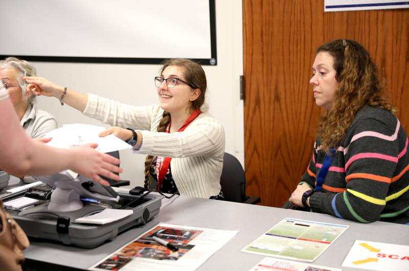 Election judges Lucia Gorski (left) and Rin Erickson assist voters at the Town and Country Library on Tuesday, Nov. 5, 2024 in Elburn.