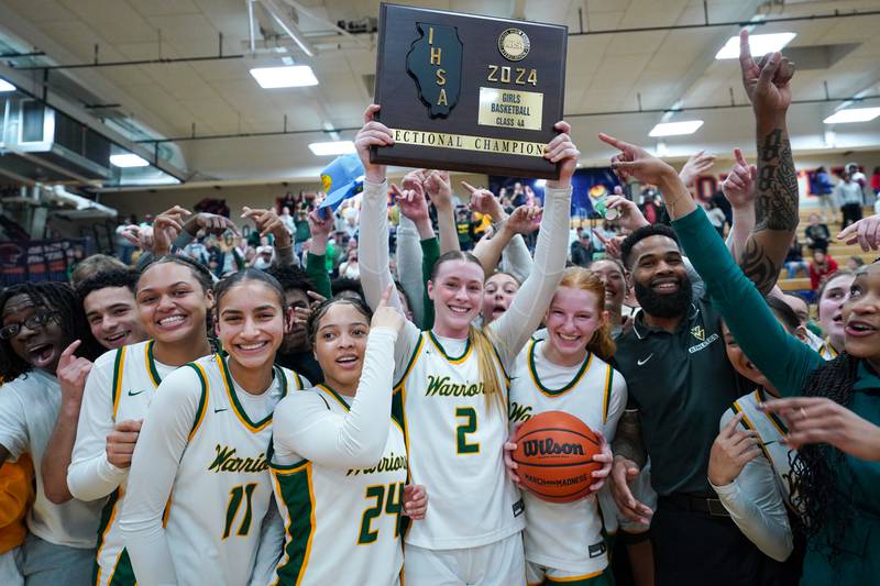 Waubonsie Valley players raise the championship 4A sectional plaque after defeating Benet in overtime at Oswego High School on Thursday, Feb 22, 2024.