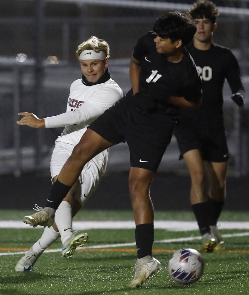 Prairie Ridge's Gabriel Porter takes a shot at goals as he is defended by McHenry's Yahel Garcia during a Fox Valley Conference soccer match on Tuesday, Oct. 15, 2024, at McCraken Field in McHenry.
