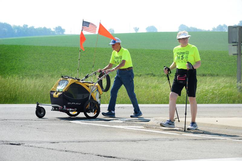 Kathy Woodward checks for traffic as she walks with Dean Troutman at the intersection of Illinois 26 and Illinois 64, between Forreston and Polo, on Sunday, June 4. Troutman, 92, of Princeville, Illinois, is walking to raise money for St. Jude's. Woodward of Galesburg, walked with Troutman from Dixon to Forreston. Her husband, Gene, followed them in the couple's vehicle. Woodward returned home on Sunday. Troutman his trek by himself, but invites others to join him during his daylight hours.