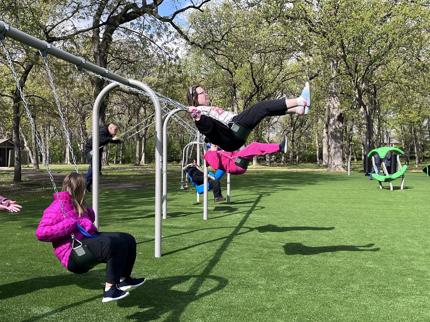 Attendees of a ribbon-cutting ceremony enjoy the swing set at Inwood Park playground on Friday, May 1, 2026, in Joliet.