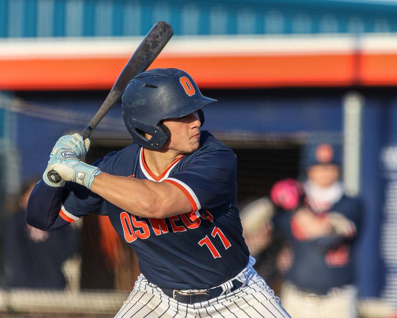 Oswego's Isaiah Logan (11) eyes a pitch during baseball game between Plainfield South at Oswego on Monday, April 14, 2025 in Oswego.