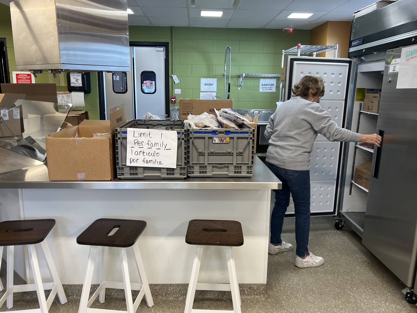 Lifelong Genoa resident Linda Bugna, on March 25, 2025, pulls out produce from a refrigerator at the Genoa Area Community Food Hub.