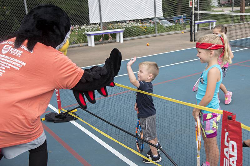 Jack Reuter gets a high five from Slammin’ Sammy, the Sauk Valley Community College mascot during the tiny tots event at the Emma Hubbs Tennis Classic Monday, July 25, 2022. SVCC is a major sponsor to this year’s classic.