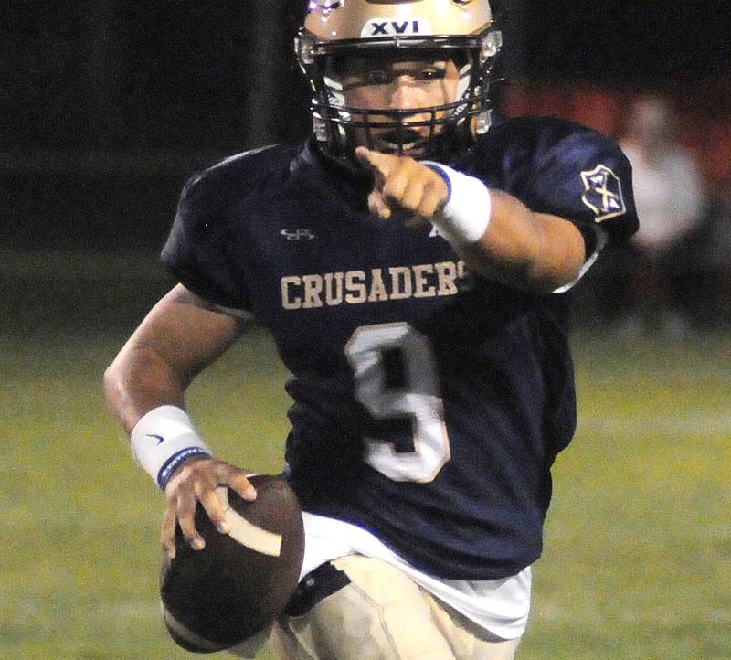 Marquette quarterback Alex Graham directs points out some potential blocks while scrambling against Dee-Mack at Gould Stadium on Friday, Sept. 9, 2022.