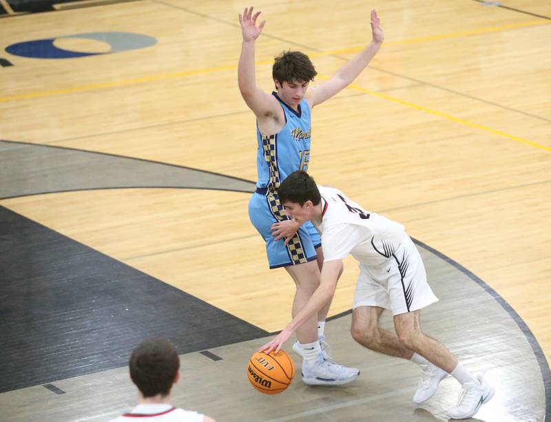 Woodland's Nick Plesko gets by Marquette's Alec Novotney to run into the lane during the Tri-County Conference Tournament on Tuesday, Jan. 28. 2025 at Putnam County High School.