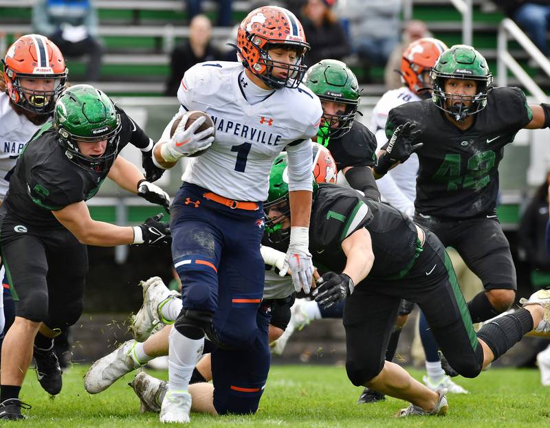 Naperville North's Cole Arl (1) tries to escape a swarm of Glenbard West tacklers during an IHSA Class 8A playoff game on Oct. 28, 2023 at Glenbard West High School in Glen Ellyn.