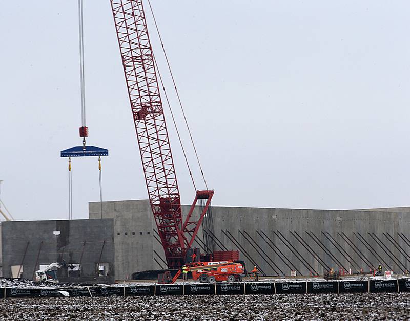 Workers use a large crane to lift a portion of an exterior wall at the new GAF Commercial Roofing manufacture on Tuesday, Jan. 24, 2023 in Peru. Last July, GAF and the City of Peru announced $80 million, 450,000 square foot manufacturing facility that broke ground in late 2022. The plant will employ more than 70 workers and will be located north of Interstate 80 and west of Plank Road on the OmniTRAX rail line.