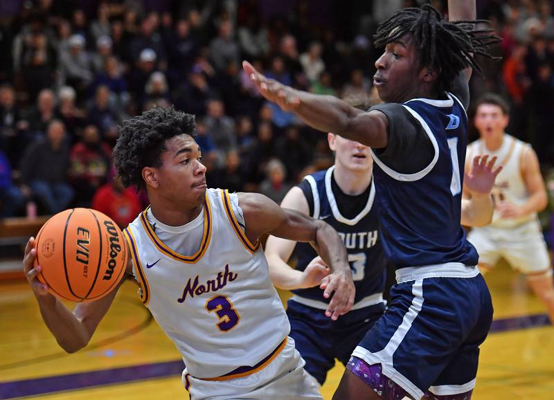 Downers Grove North’s Kam Ganier (3) starts to pass as Downers Grove South’s Antonio Evans Jr. defends during a game on December 20, 2025 at Downers Grove North High School in Downers Grove.