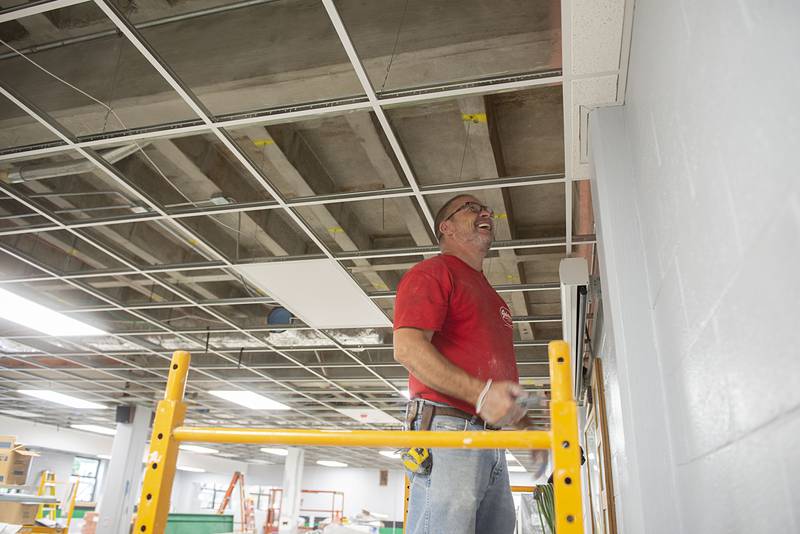 Joel Plum of Gehrke Construction works on the ceiling tiles Wednesday, July 27, 2022 in Rock Falls High School’s renovated cafeteria. The kitchen and dining area has undergone extensive updating.