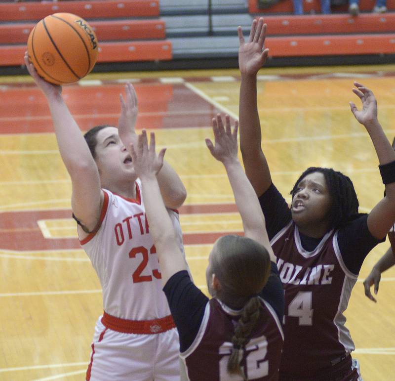 Ottawa’s Mary Stisser shoots above the block attempts by Moline’s Elle Machado and VanDarricka Reaves in the 1st period Tuesday at Ottawa.