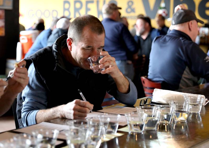 Judge Paul Young tastes one of the samples in the annual Kane County Water Association's annual water-tasting contest at Global Brew in St. Charles on Thursday, Dec. 21, 2023.