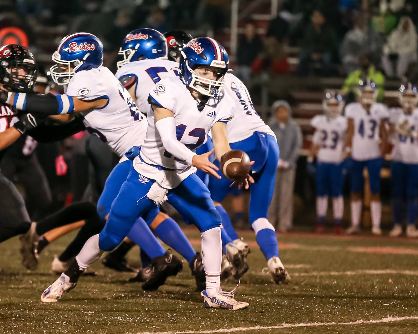 Glenbard South's Michael Champagne (12) pitches the ball to  Cam Williams (8) during football game between Glenbard South at Glenbard East.   Oct 13, 2023.