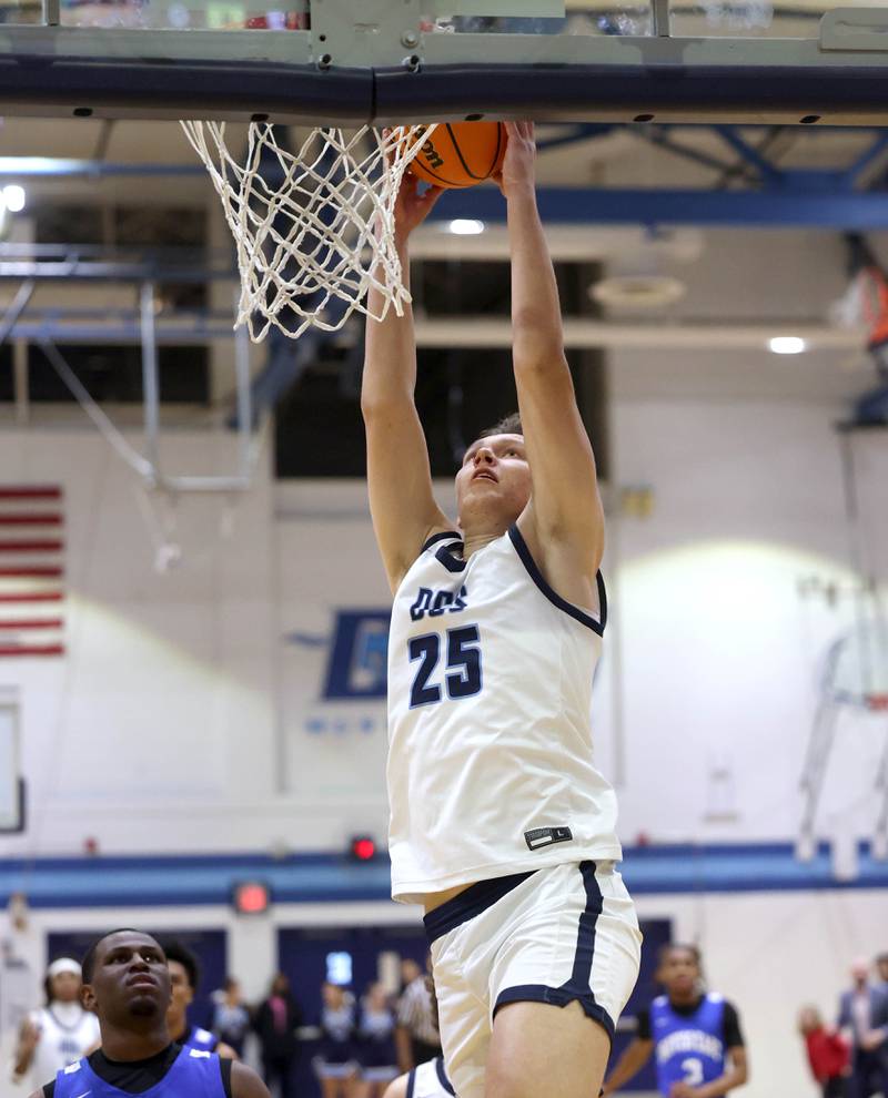 Downers Grove South's Daniel Sveiteris dunks the ball in front of Proviso East's Jerry Johnson during their game Friday, Feb. 14, 2025, at Downers Grove South High School.