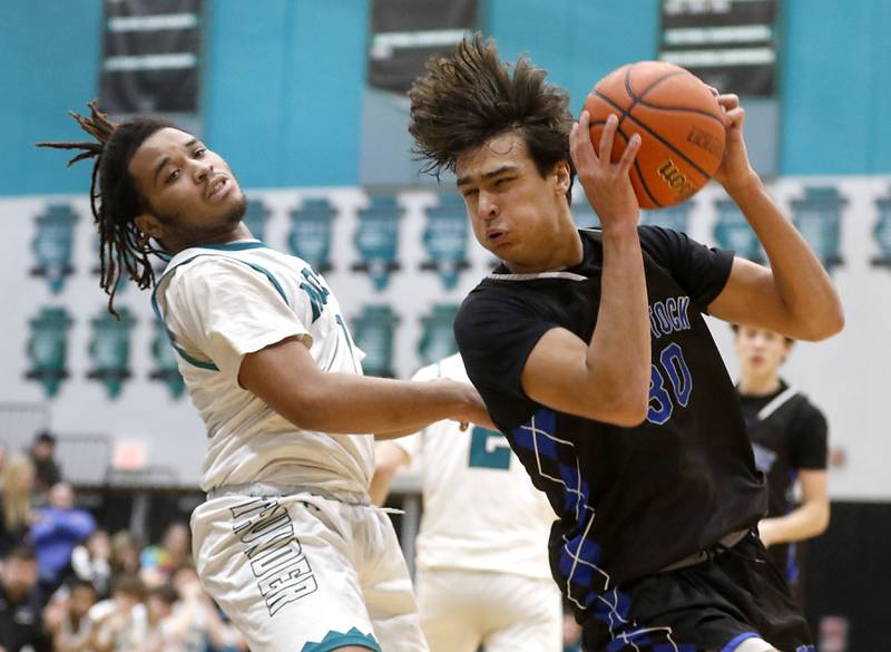 Woodstock's Spencer Cullum spins tot he basket as he drives against Woodstock North's Elijah White during a Kishwaukee River Conference boys basketball game on Friday, Jan. 5. 2024, at Woodstock North High School.