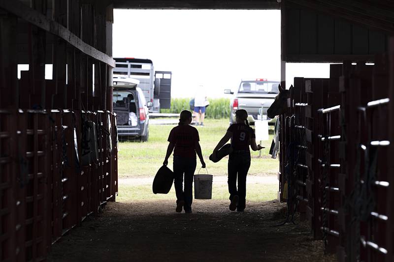 Girls walk through the horse stable Sunday, July 28, 2024, as the Lee County Fair comes to a close.