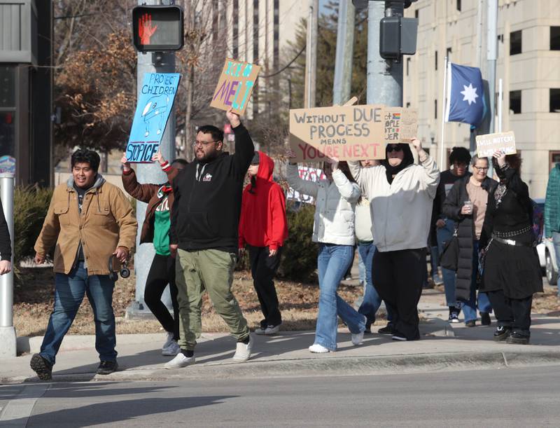 Northern Illinois University cross Lincoln Highway Friday, Feb 13, 2026, on their way to the DeKalb Police Department to protest against recent U.S. Immigration and Customs Enforcement activity.