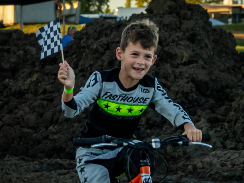Wesley Rosengren waves race flag on Saturday, August 31, 2024 at the Tri County Fair in Mendota.