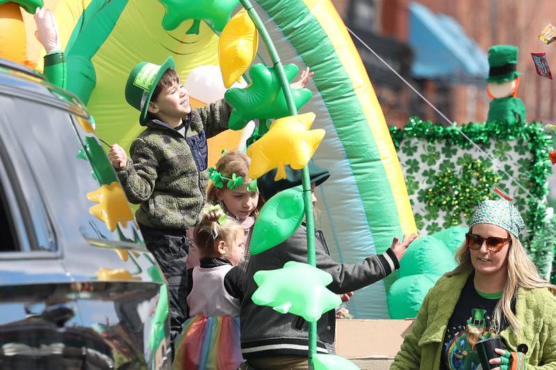 Kids throw candy to the crowds from a float in the Plainfield Hometown Irish Parade on Sunday, March 17, 2024 in Plainfield.