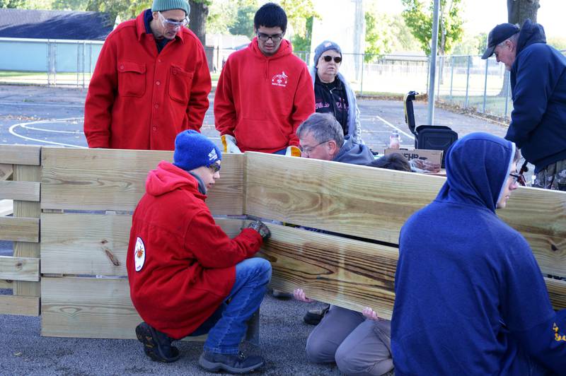 Gab Buelvas, 17, of Dixon, (blue hat), helps properly line up one of the side boards of the gaga ball pit he led about 15 people in building for Vaile Park on Saturday, Oct. 7, 2023. The gaga ball pit was Buelvas' Eagle Scout project.