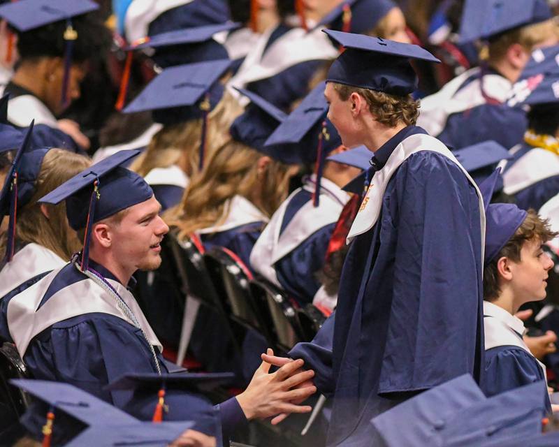 Oswego High School seniors congratulate each other after receiving their diplomas on Saturday May 17, 2025, during the graduation Ceremony held at the Convocation Center in DeKalb.