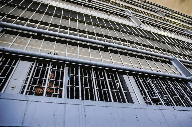 A prisoner looks through the bars of his cell on Feb. 11, 2014, at Stateville Correctional Center in Crest Hill.