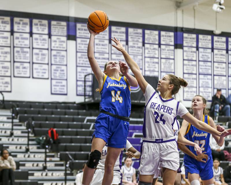 Johnsburg's Summer Toussaint (14) puts up a shot defended by Plano's Chloe Rowe (24) during their basketball game between Johnsburg at Plano, Monday Dec 16, 2024 in Plano.