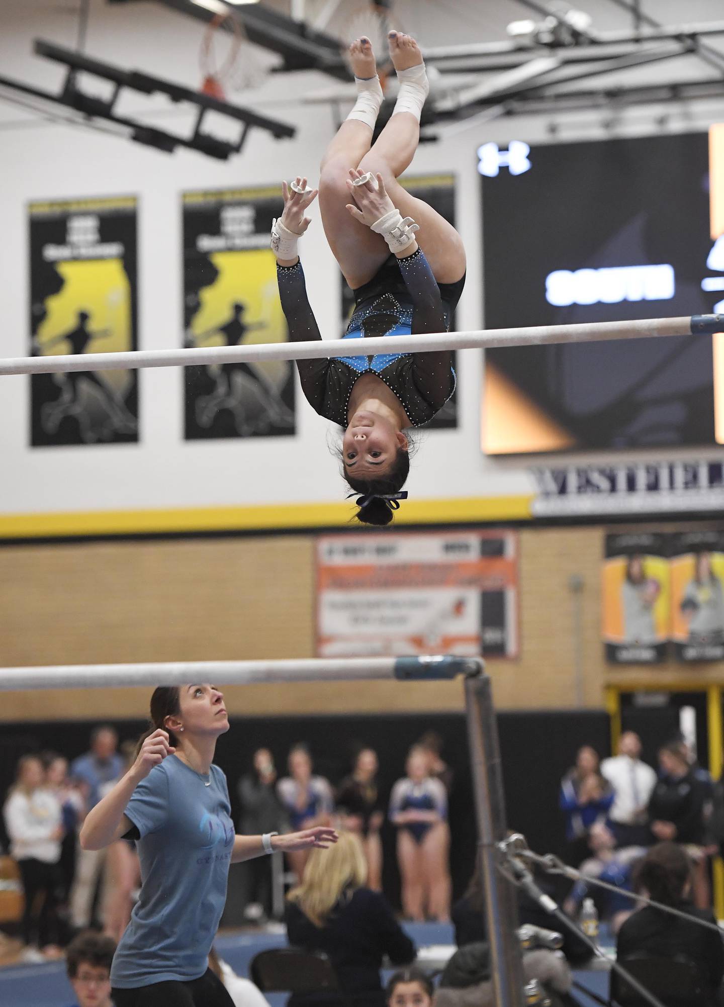 Genevieve Herion of Downers Grove South High School on the uneven parallel bars at the Hinsdale South girls gymnastics sectional meet in Darien on Tuesday, February 7, 2023.