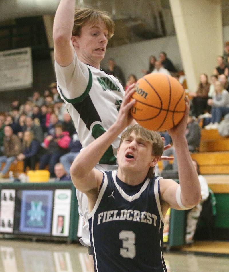 Fieldcrest's Eddie Lorton eyes the hoop as Midland's Dominic Rosa defends on Wednesday, Feb. 19, 2025 at Midland High School.