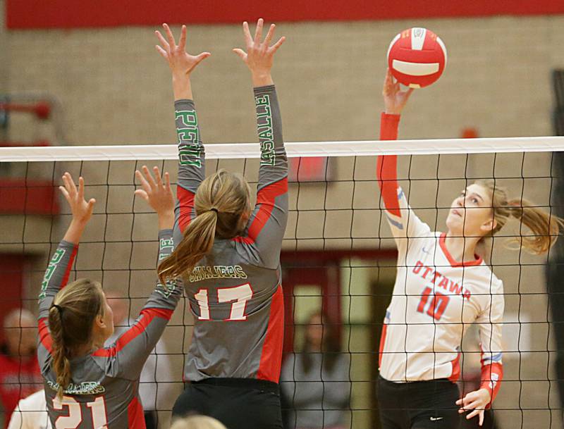 Ottawa's Lauren Denny (10) spikes the ball over L-P's Jayden Dyke (21) and teammate Olivia Shetterly (17) on Tuesday, Oct. 18, 2022 at Kingman Gymnasium in Ottawa.