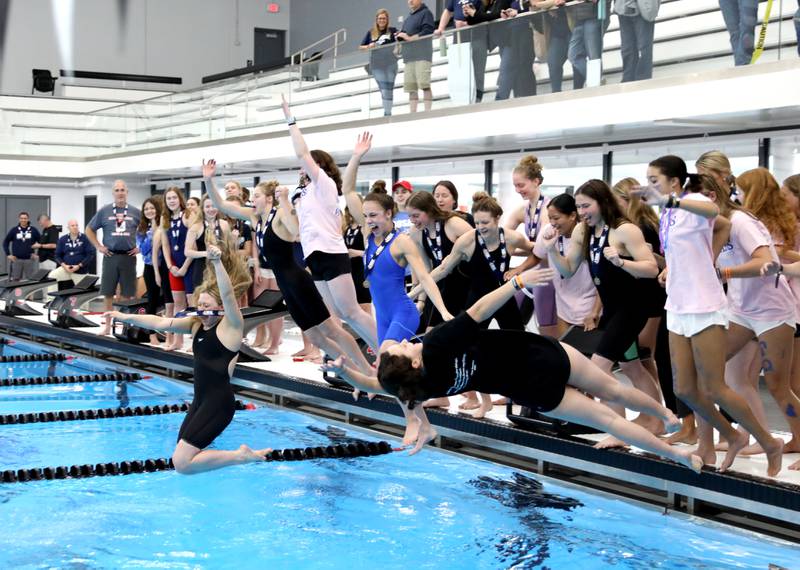 Rosary swimmers celebrate their first place state trophy in the IHSA Girls State Swimming and Diving Championships at the FMC Natatorium in Westmont on Saturday, Nov. 11, 2023.