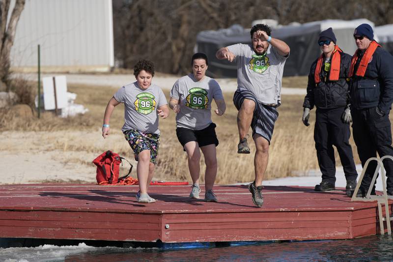 Ellen Nabeti (center) and team Simon’s Squad members leap into freezing waters at the 2025 Penguin Plunge Saturday, Jan. 25, 2025 at Skydive Chicago in Ottawa.