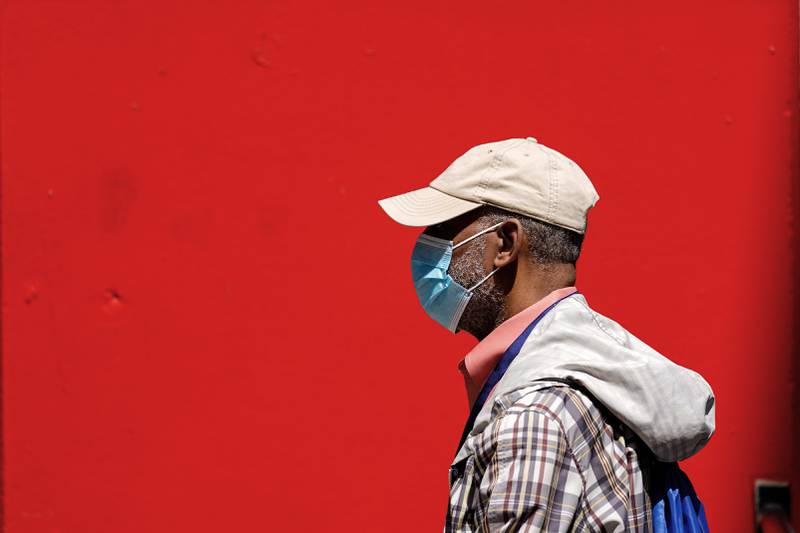 A pedestrian wearing a protective mask as a precaution against the spread of the coronavirus walks in Philadelphia, Friday, April 22, 2022.  The city abandoned its indoor mask mandate Friday, just days after becoming the first U.S. metropolis to reimpose compulsory masking in response to an increase in COVID-19 cases and hospitalizations. (AP Photo/Matt Rourke)
