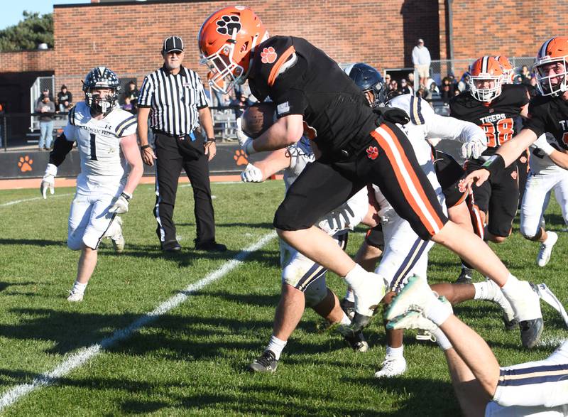 Byron's Kole Aken (5) jumps over a tackler as he runs for gain against Elmhurst IC Catholic during 3A quarterfinals at Byron High School on Saturday, Nov. 15, 2025.