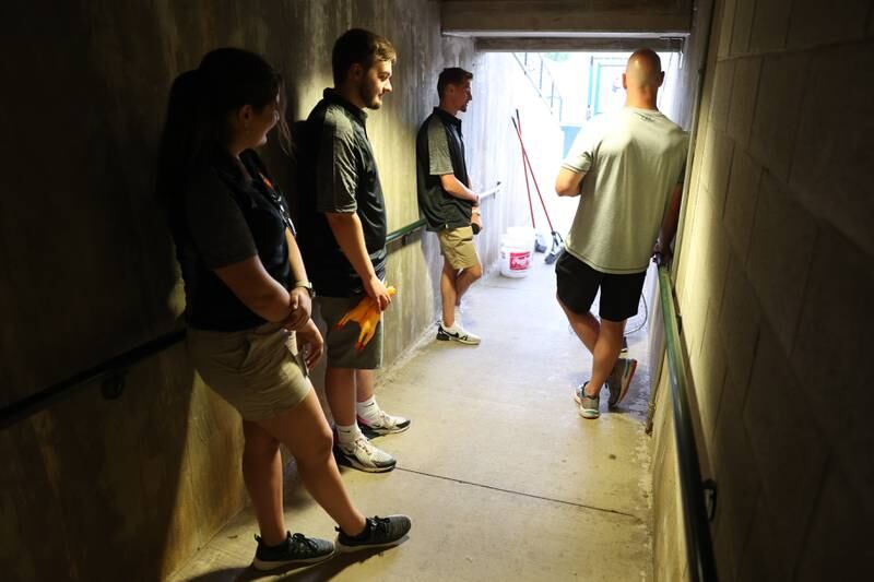Joliet Slammers’ staff and a fan wait for a game break to partake in a contest at the home opener against the Ottawa Titans. Friday, May 13, 2022, in Joliet.